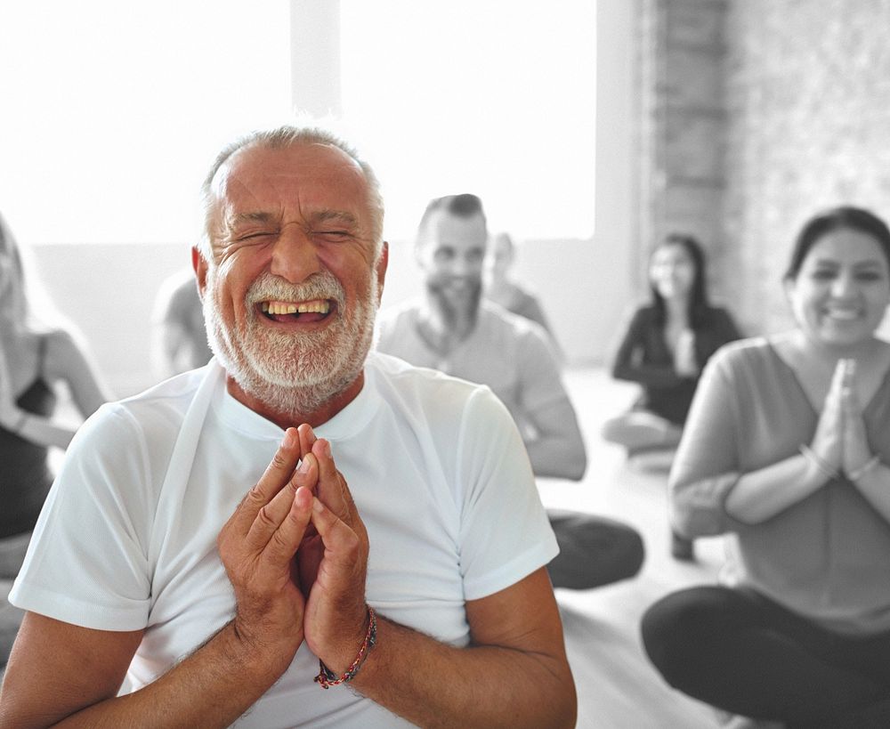 Smiling old man in yoga class