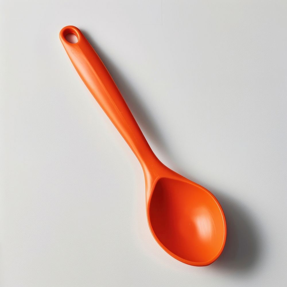 Bright orange plastic kitchen spoon