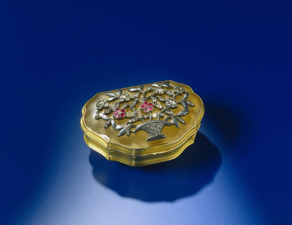 Snuifdoos van goud met deksel van chalcedoon. De geschulpte doos is versierd met een bloemenmand in reliëf van zilver, met…