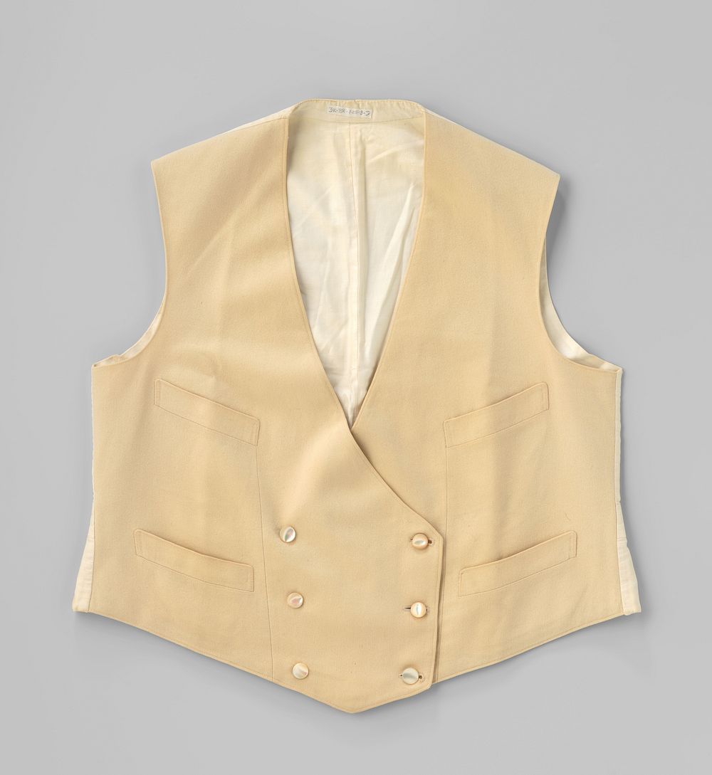 Vest met vier steekzakken en tweemaal drie parelmoeren knopen van crèmekleurige wol; de achterzijde met ceintuur en gesp en…