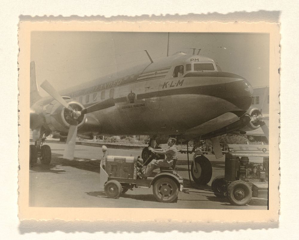 KLM-toestel The Flying Dutchman, met op de voorgrond een karretje voor het vervoer van bagage en andere spullen van en naar…
