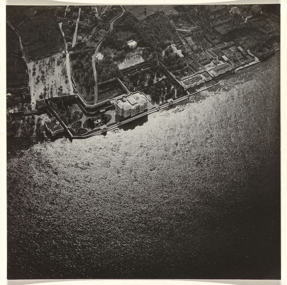 Luchtfoto in zwart-wit van een stad of dorp, gelegen aan het water met een gebouw (1930 - 1975) by anonymous