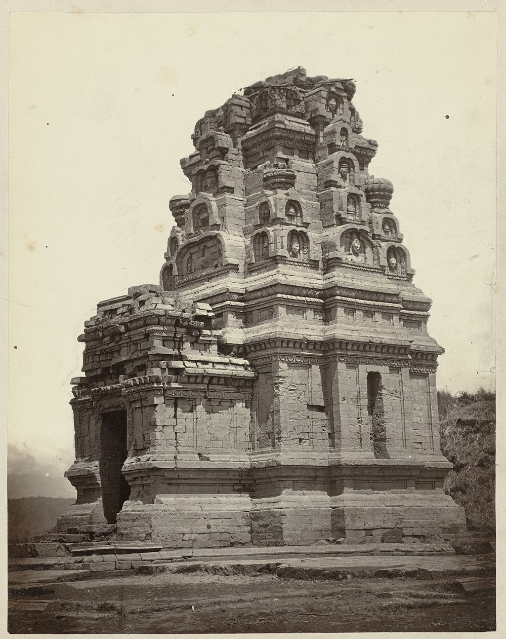 Candi Bhima, general view including its superstructure with sculpted heads and entrance. Dieng plateau, Wonosobo district…