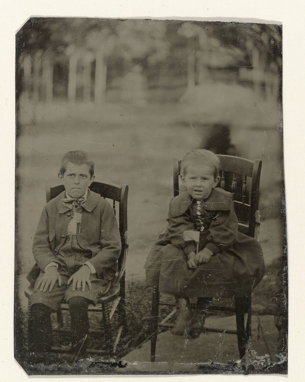 Portret van twee jongens, zittend op een stoel in een tuin of park (c. 1860 - c. 1900) by anonymous