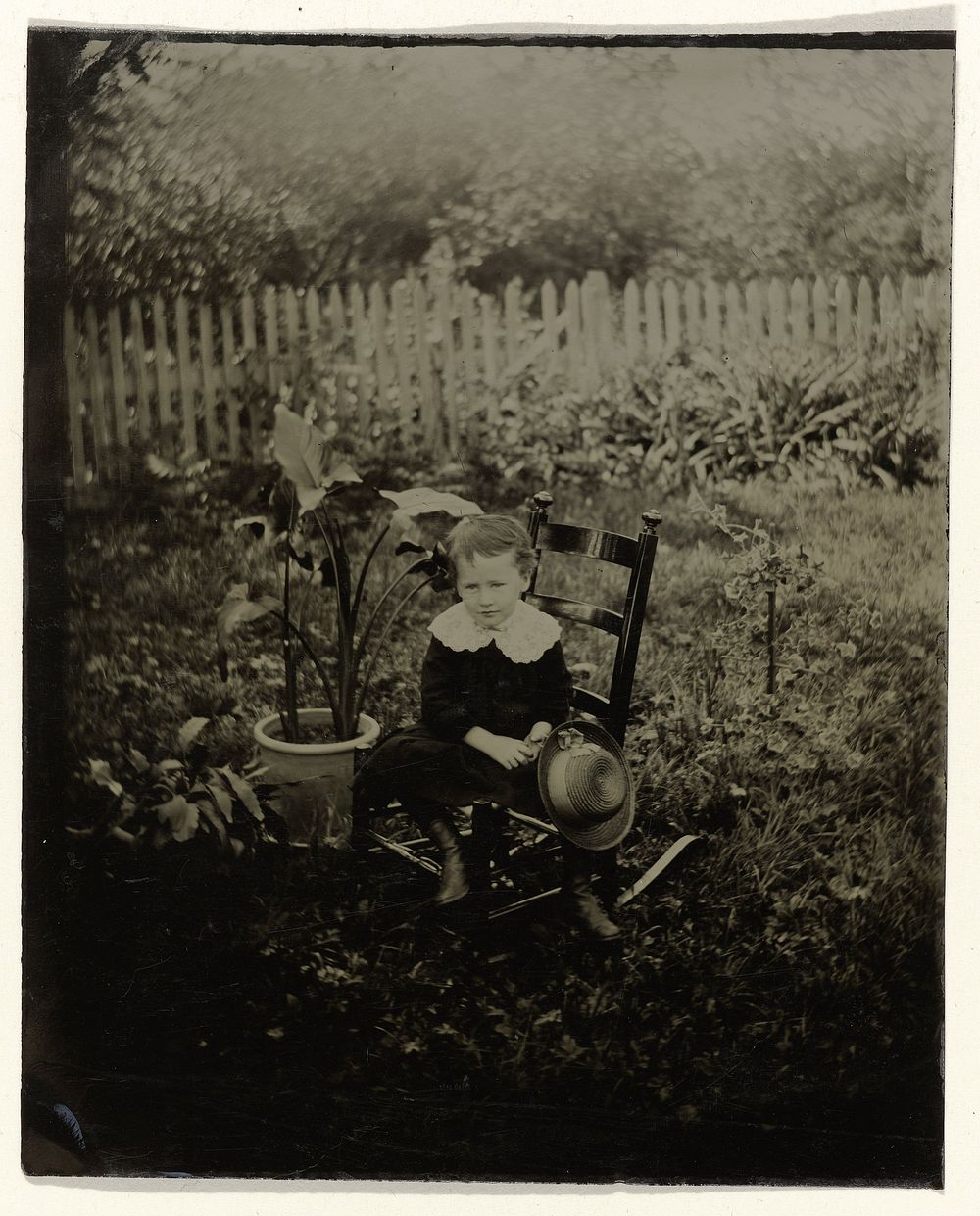 Portret van een jongen, zittend op een stoel in een tuin (c. 1860 - c. 1900) by anonymous