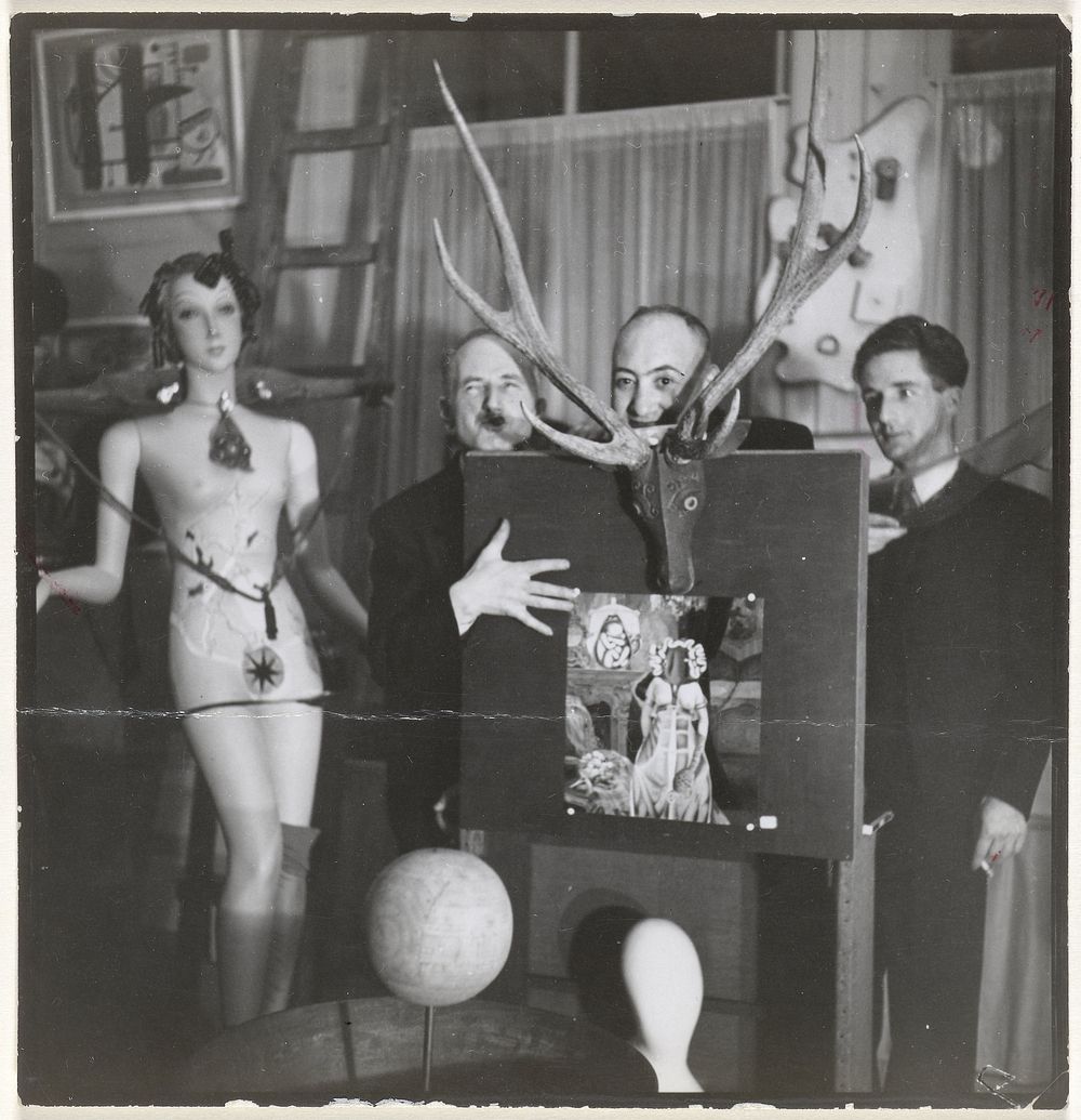 Drie mannen bij een surrealitisch kunstwerk in Galerie Robert (1938) by Lilly Samuel