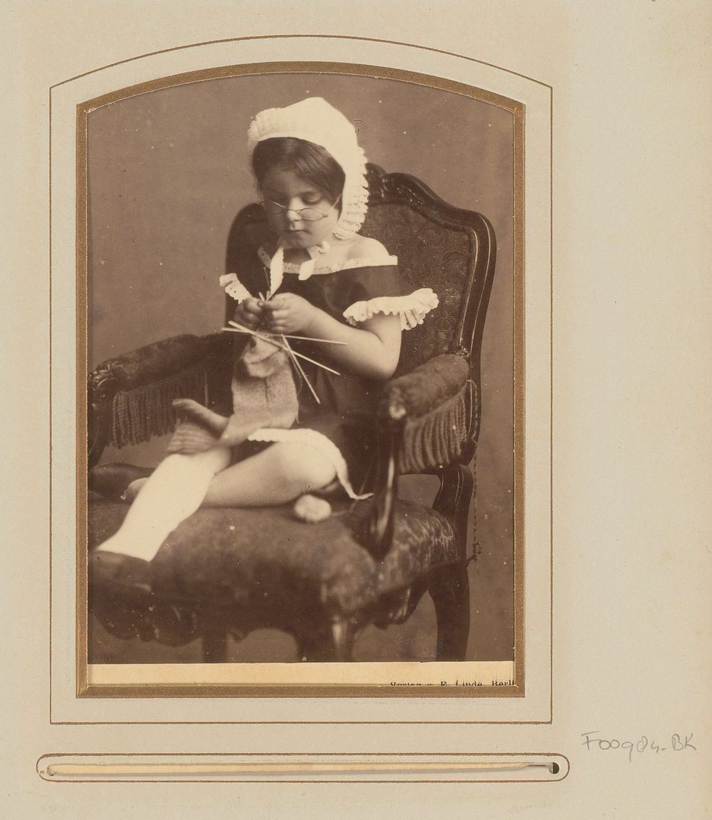 Portret van een zittend meisje met oma-muts en bril, breiend (1860 - 1900) by Halwas and E Linde