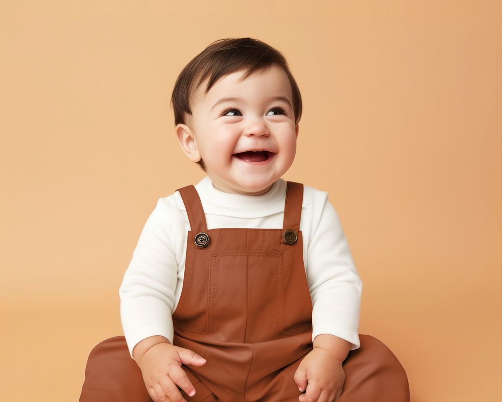 Happy baby in brown dungarees
