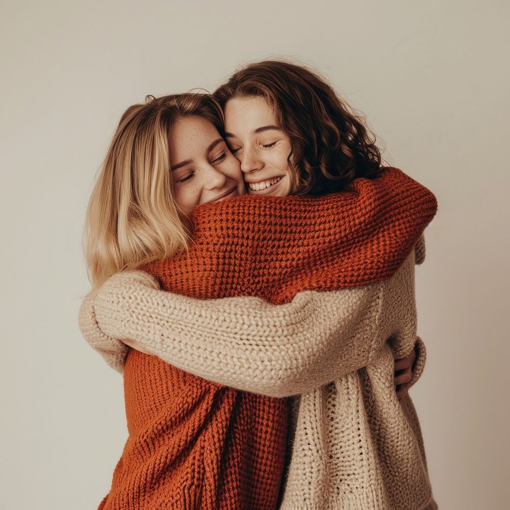 Two hugging friend sweater togetherness affectionate.