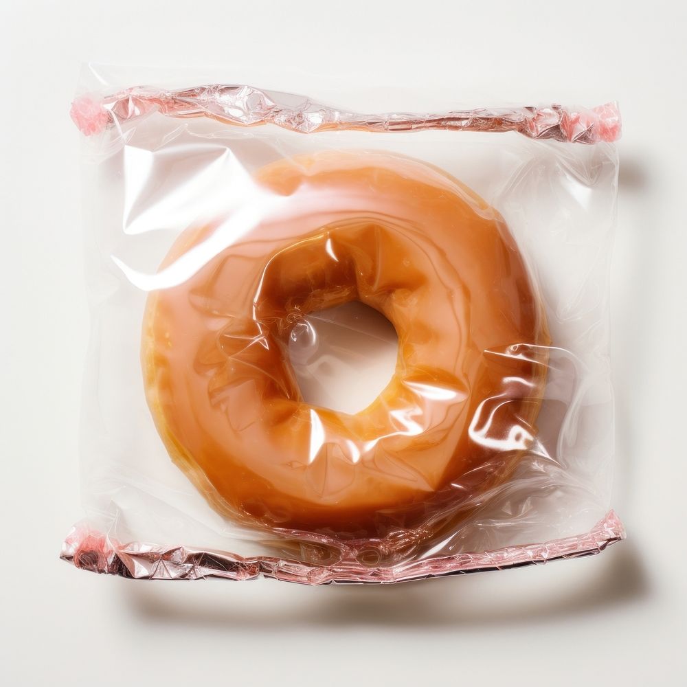Plastic wrapping over a donut bagel food white background.