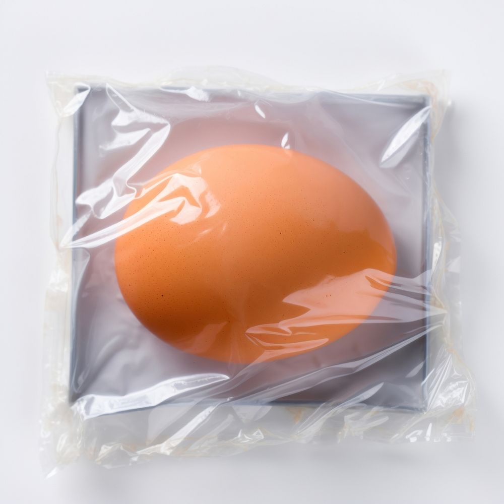 Plastic wrapping over an egg food white background freshness.