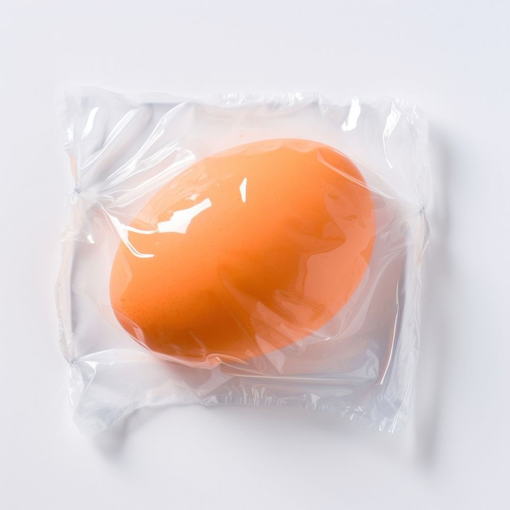 Plastic wrapping over an egg white background wrapped yellow.