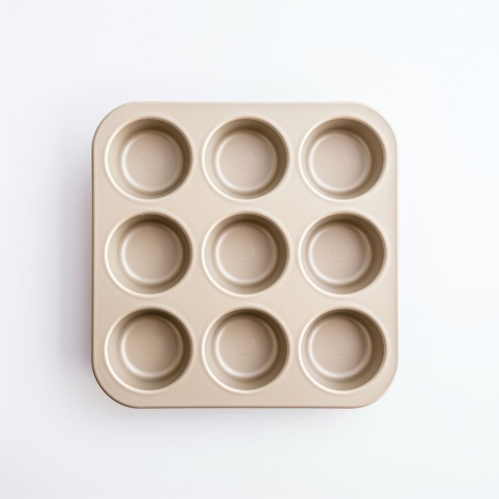 A beige muffin pan white background electronics simplicity.