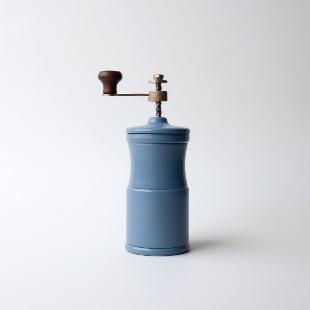 A blue minimal ceramic coffee grinder cylinder white background lighting.