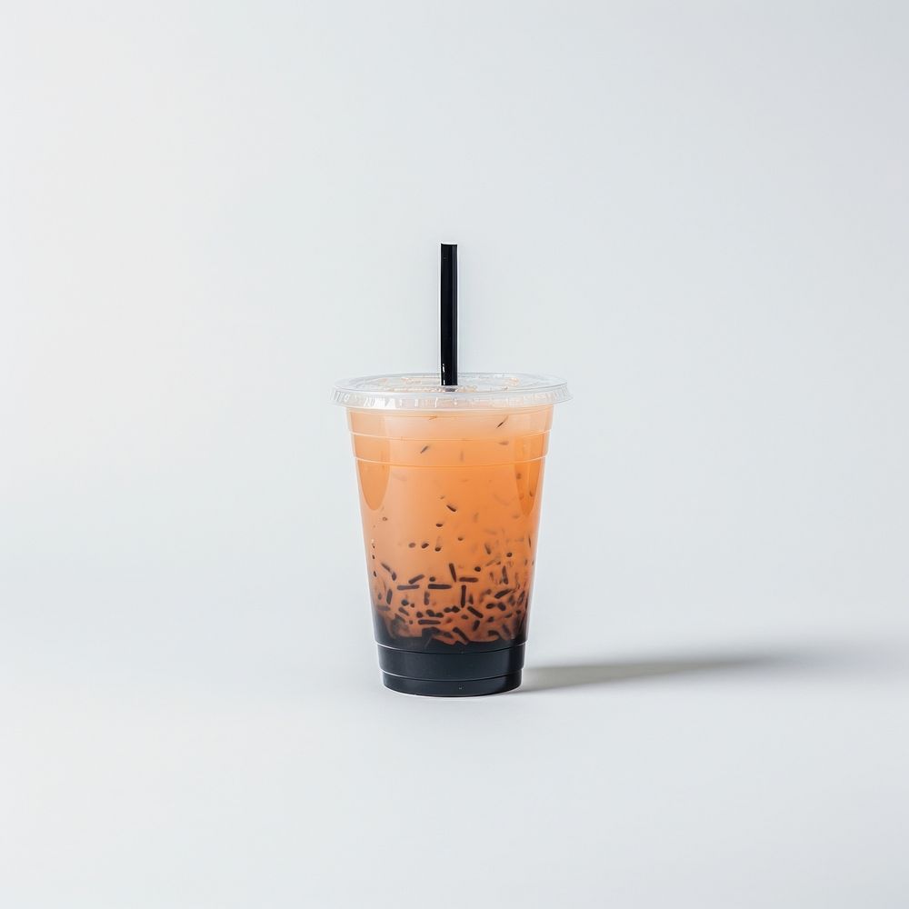 A plastic disposable ice black orange coffee glass drink cup white background.