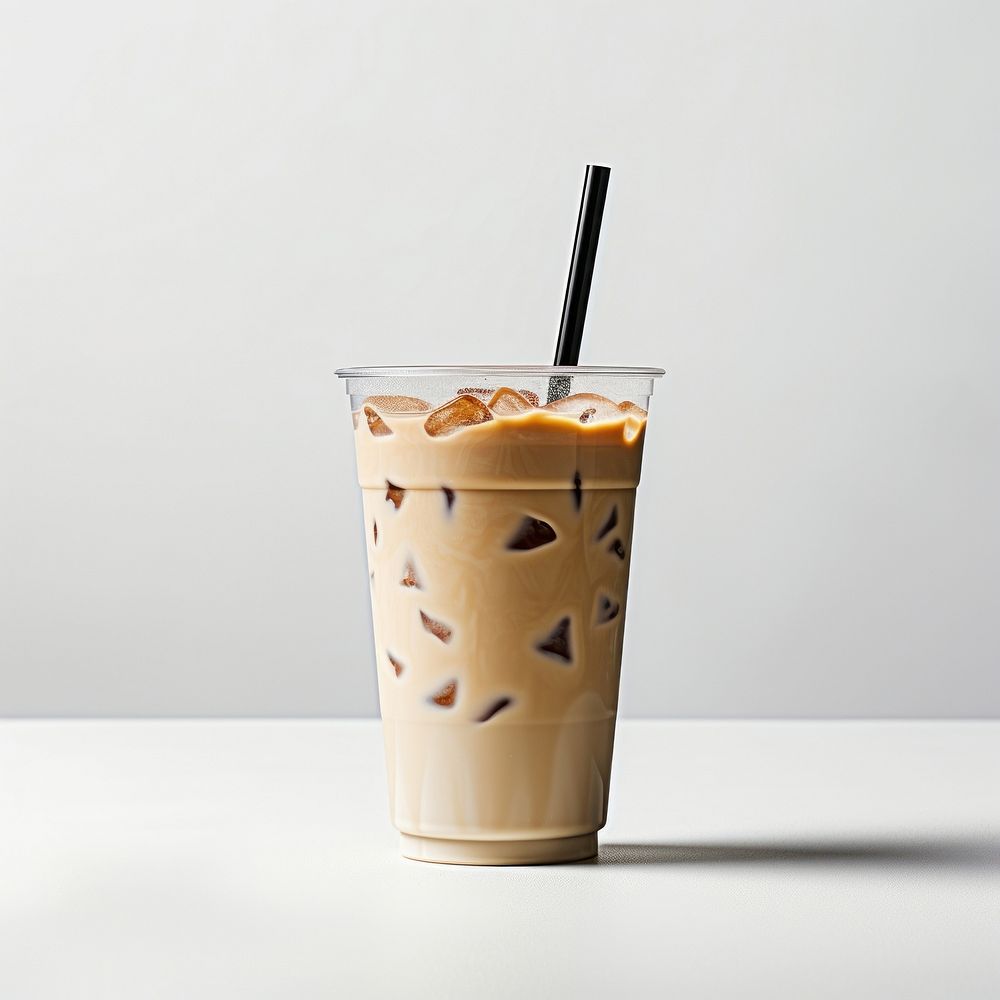 A plastic disposable ice latte coffee glass with straw and blank white label smoothie drink milk.