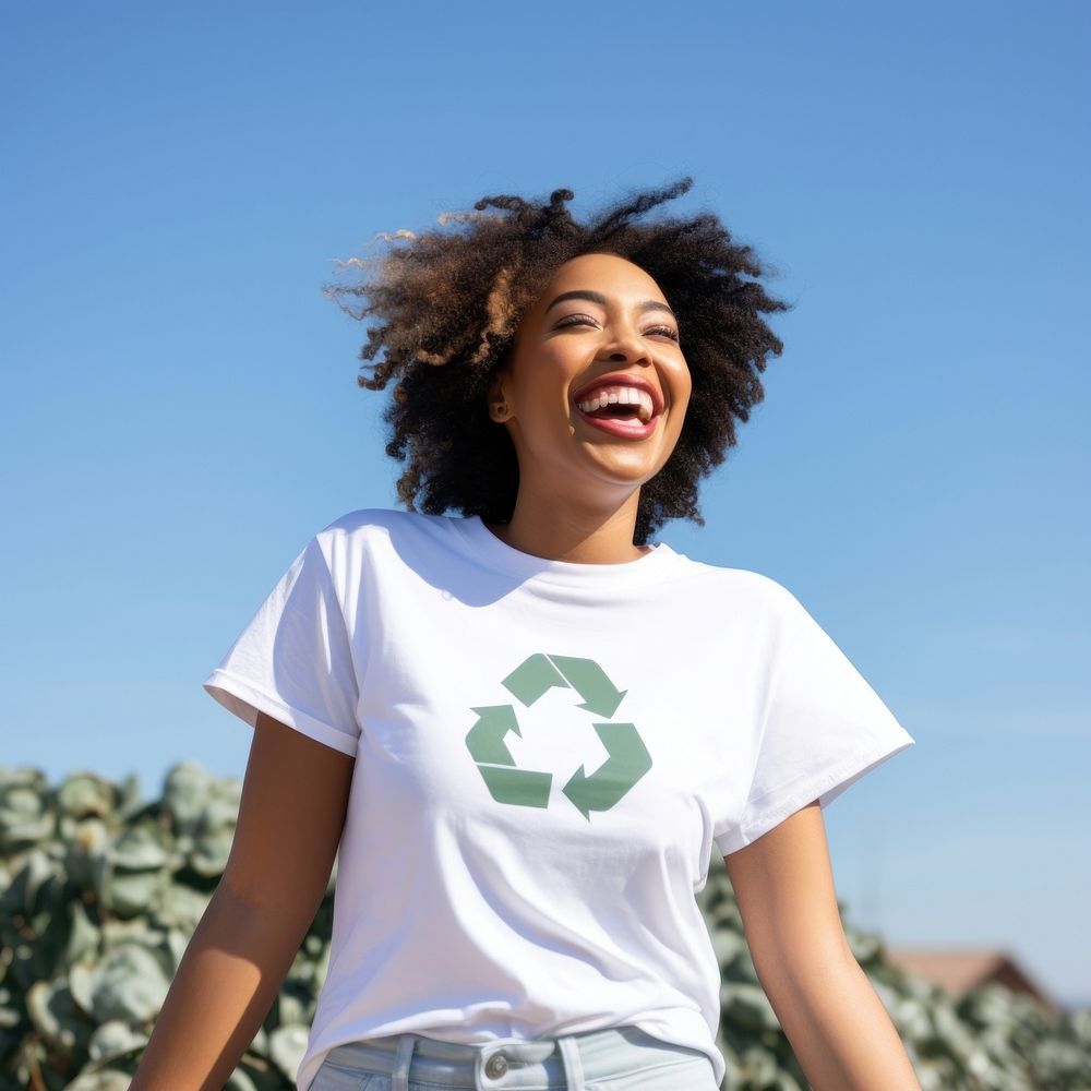 White t-shirt with recycle icon outdoors smiling green.