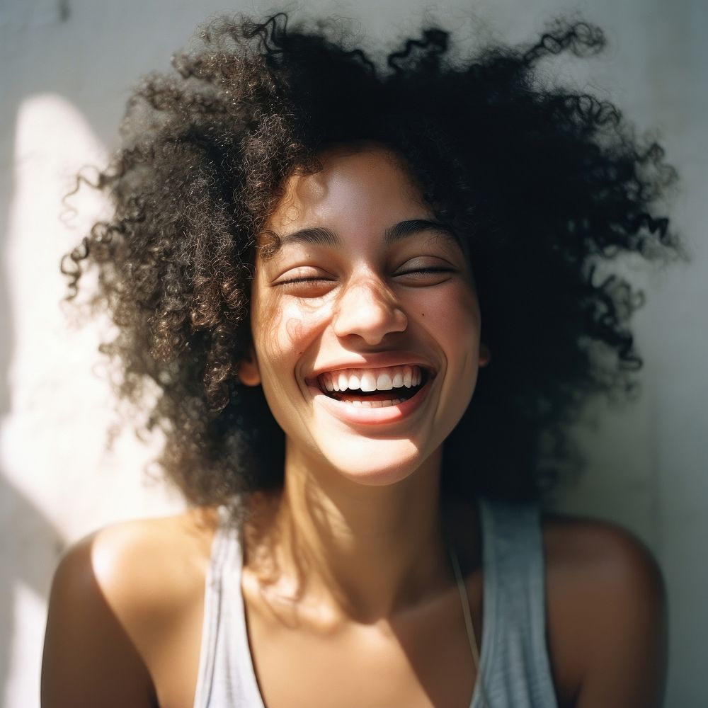A mixed race american-african woman laughing smiling smile.