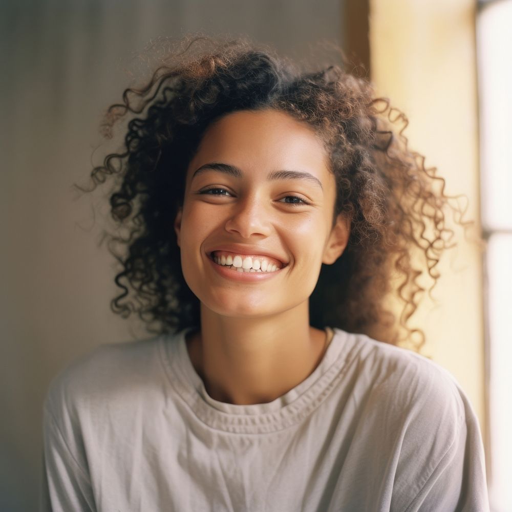 A mixed race american-african woman smiling adult smile.