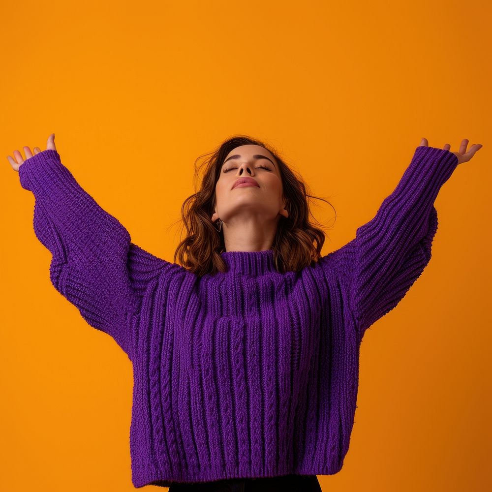 Woman in purple sweater with her arms open relaxation gesturing happiness.