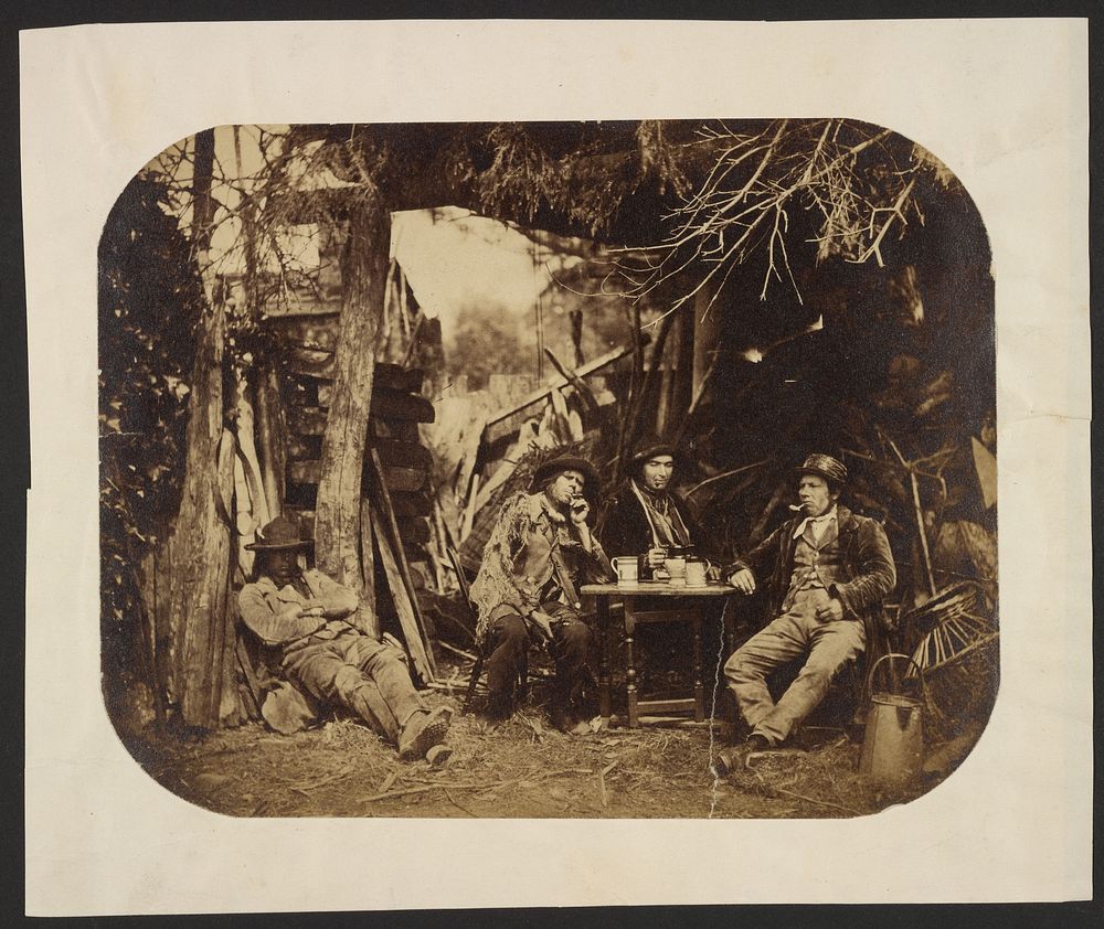 Men resting around table in a clearing