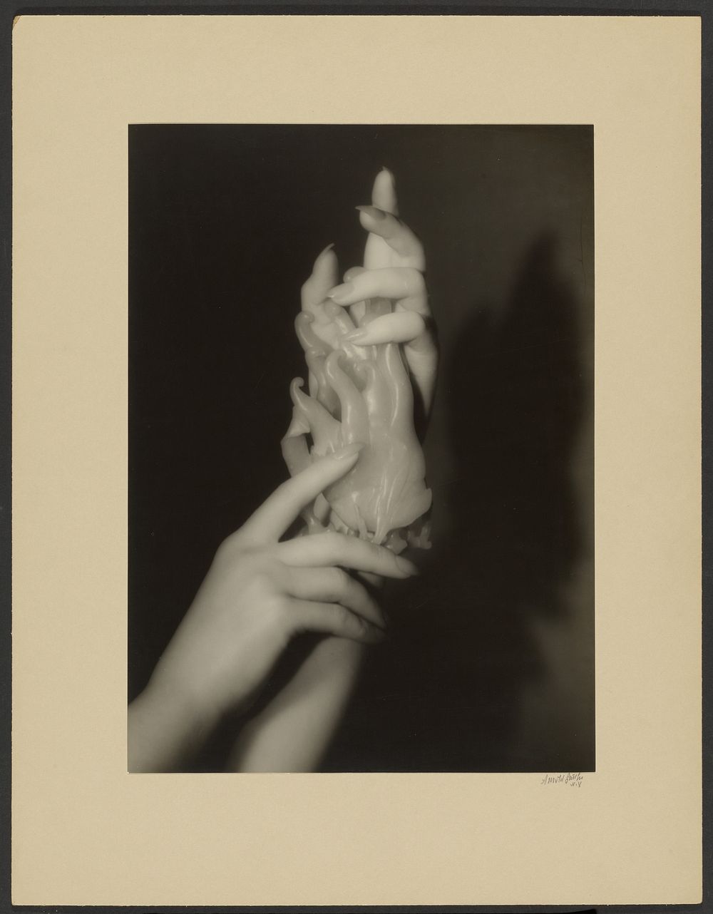 Hand study with figurine by Arnold Genthe