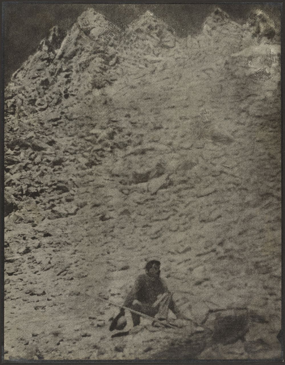 Man Crouching in Rocky Landscape by Louis Fleckenstein