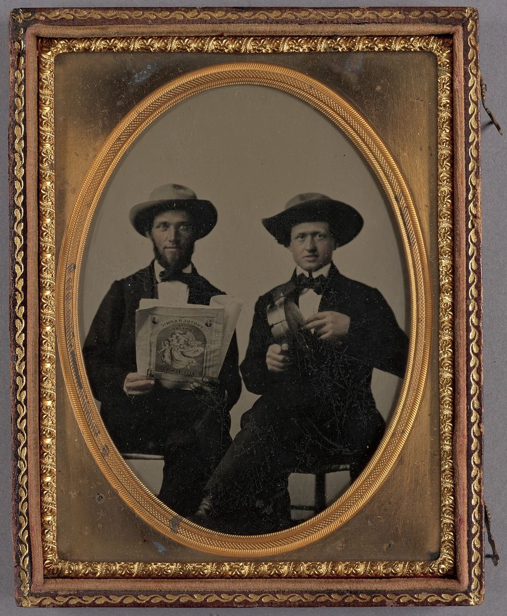 Portrait of two seated men wearing bow ties and hats