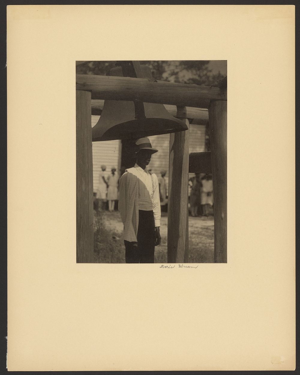 Black Man Standing Under a Bell by Doris Ulmann