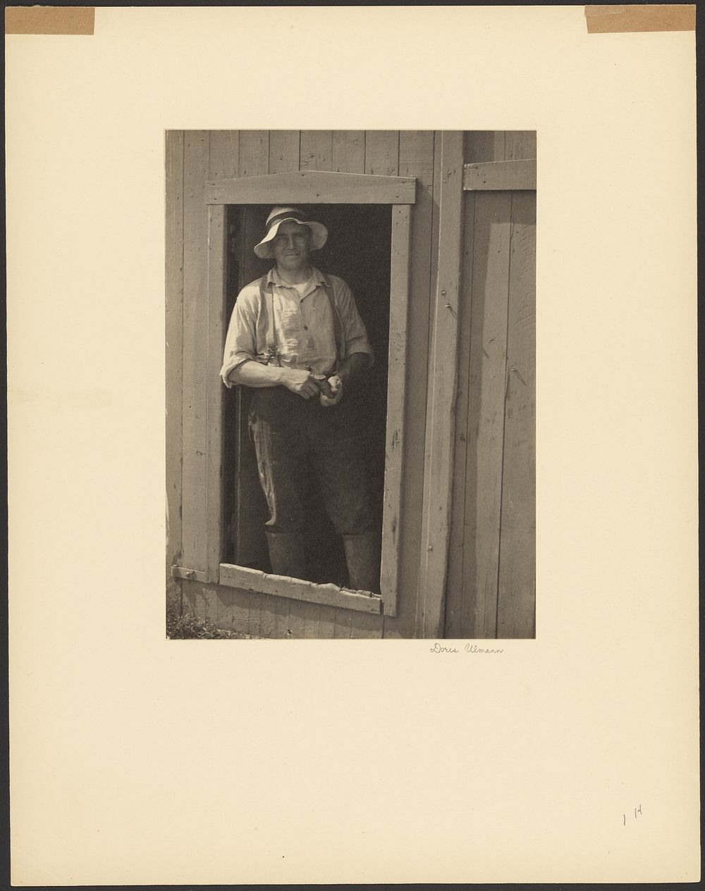 Man in a Straw Hat Standing in Doorway of a Barn Holding a Tobacco Pouch by Doris Ulmann
