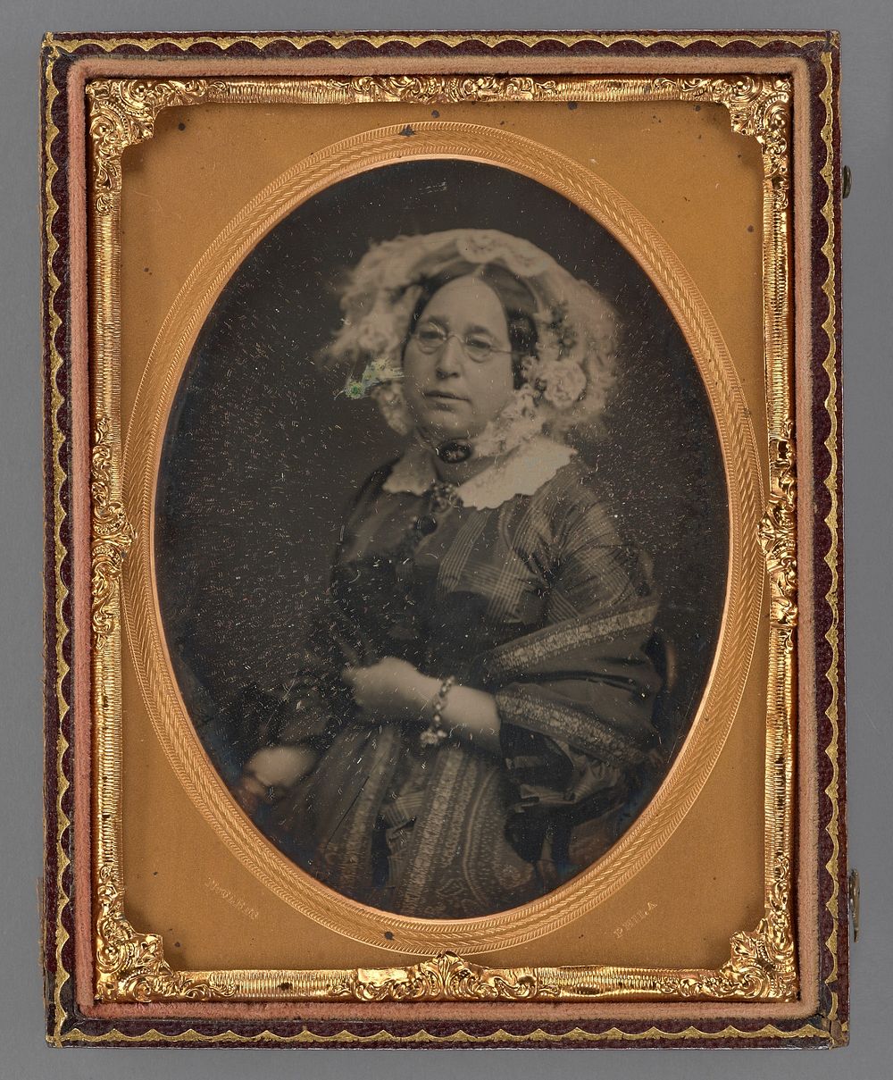 Portrait of a middle-aged woman wearing wire-rimmed glasses in flower embellished veil by James Earle McClees