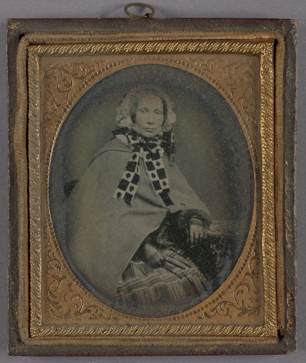 Portrait of a Seated, Middle-aged Woman in Bonnet with Patterned Tie Ribbons and Long Cloak