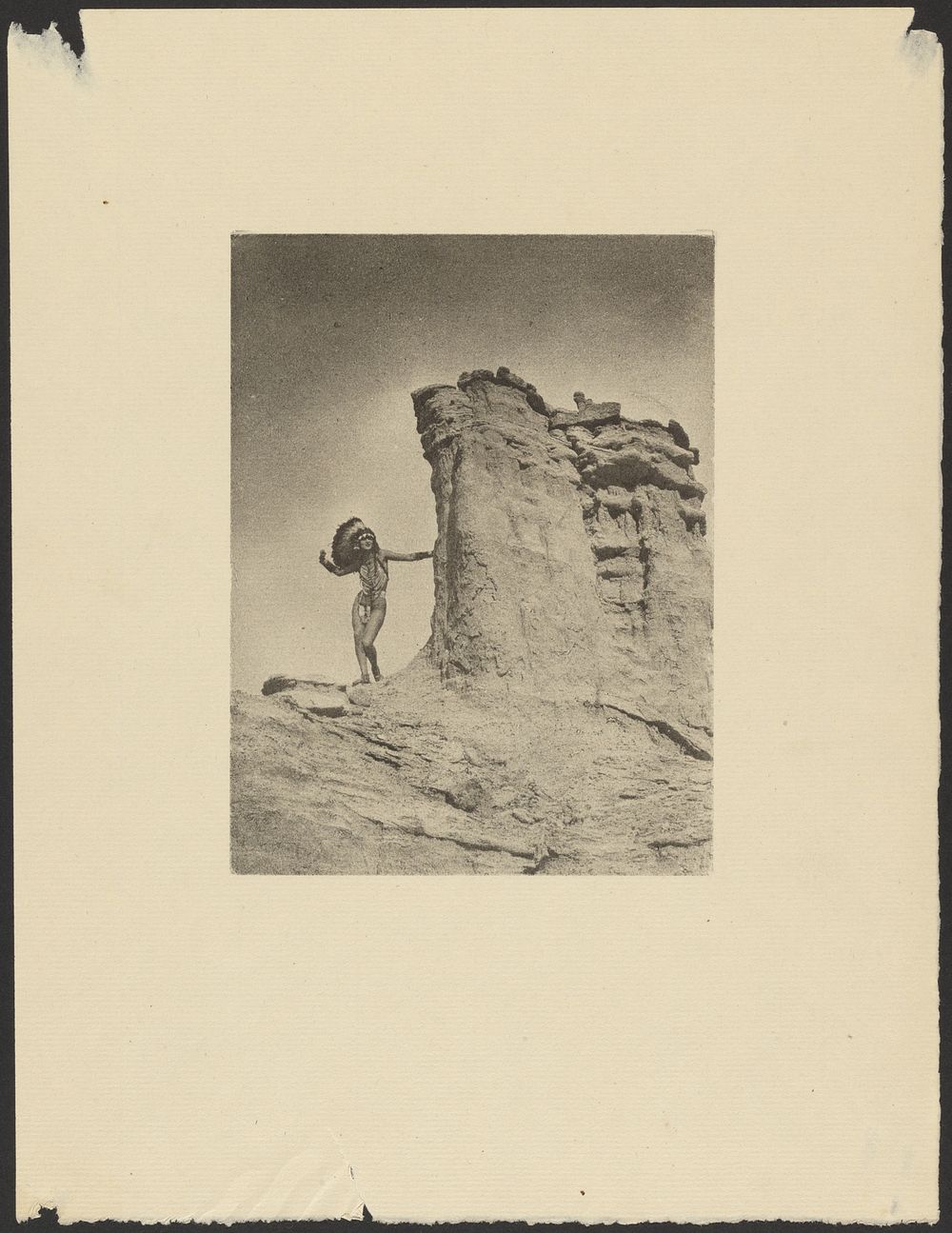 Woman in Indian Costume in the Desert Posed Next to a Large Rock Formation by Arthur F Kales