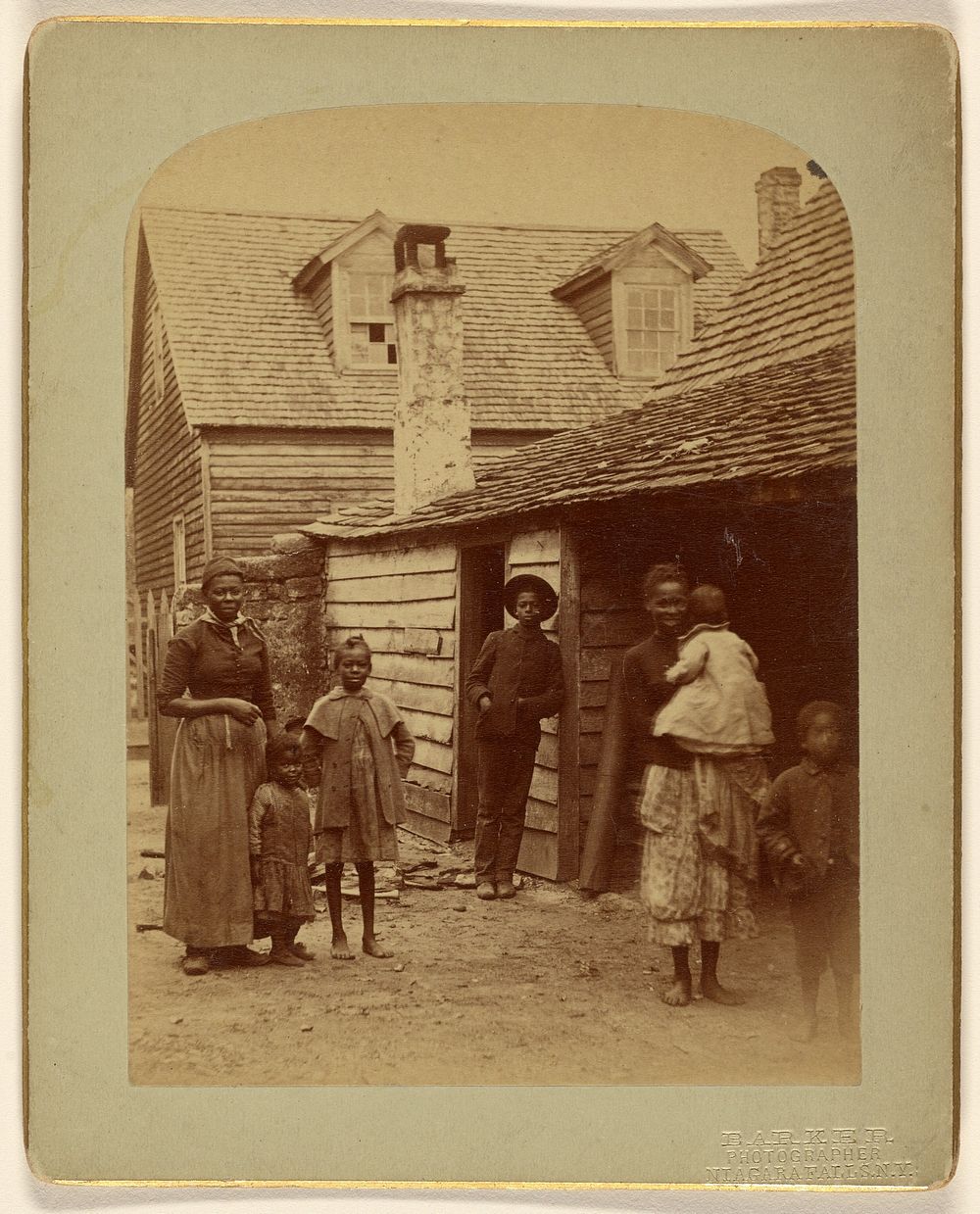 Portrait of a Black family standing in front of a house by George Barker
