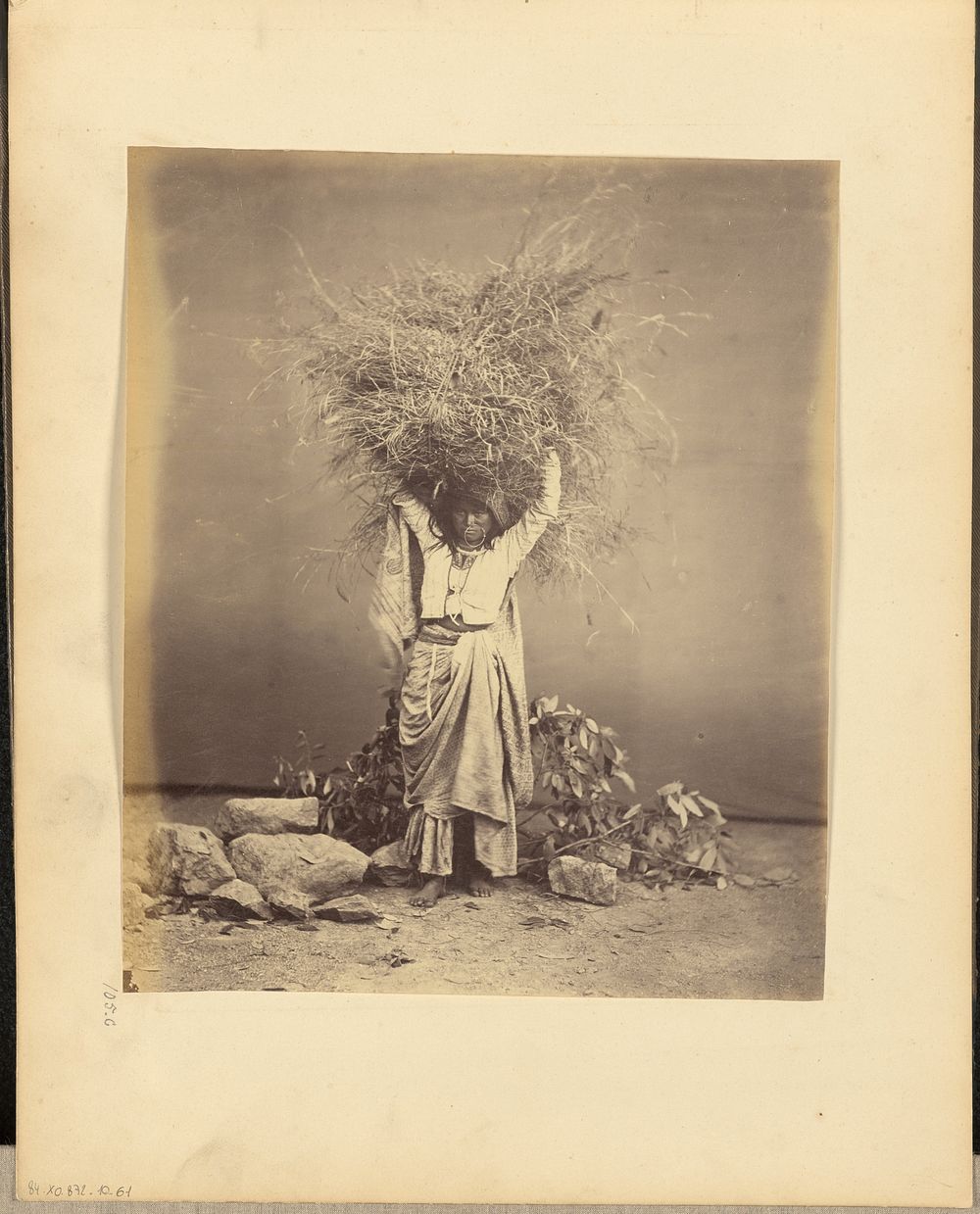 Indian peasant young woman holding twigs on her head by John Edward Saché