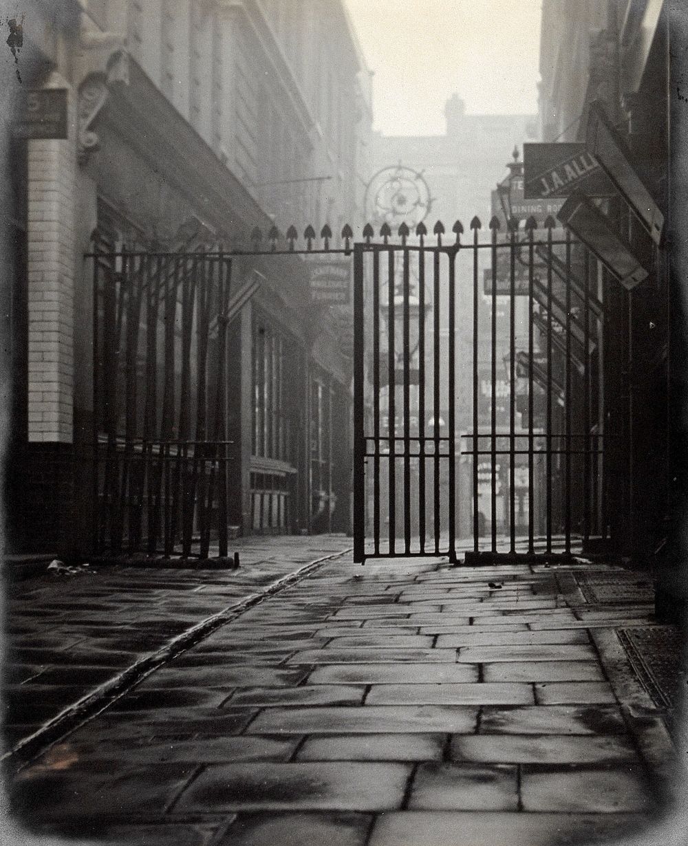 The church of St. Bartholomew the Great and surrounding area; iron gates leading to Westmorland Buildings, looking west.…