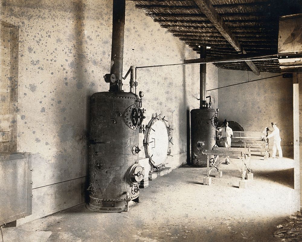 Disinfecting station: interior showing equipment and two African  men in western dress, Africa . Photograph, 1905/1925 .