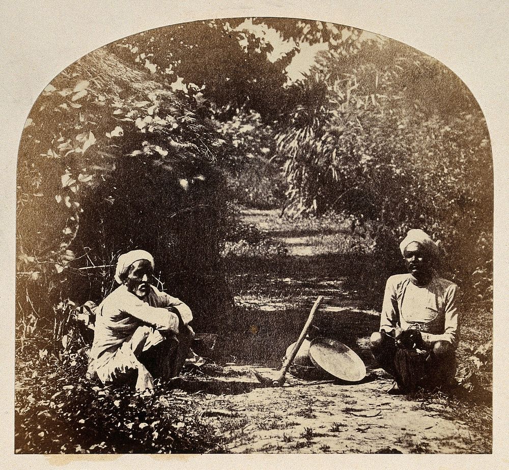 Goruckpoor, India: two men sqatting on a tree-lined path. Photograph, ca. 1860.