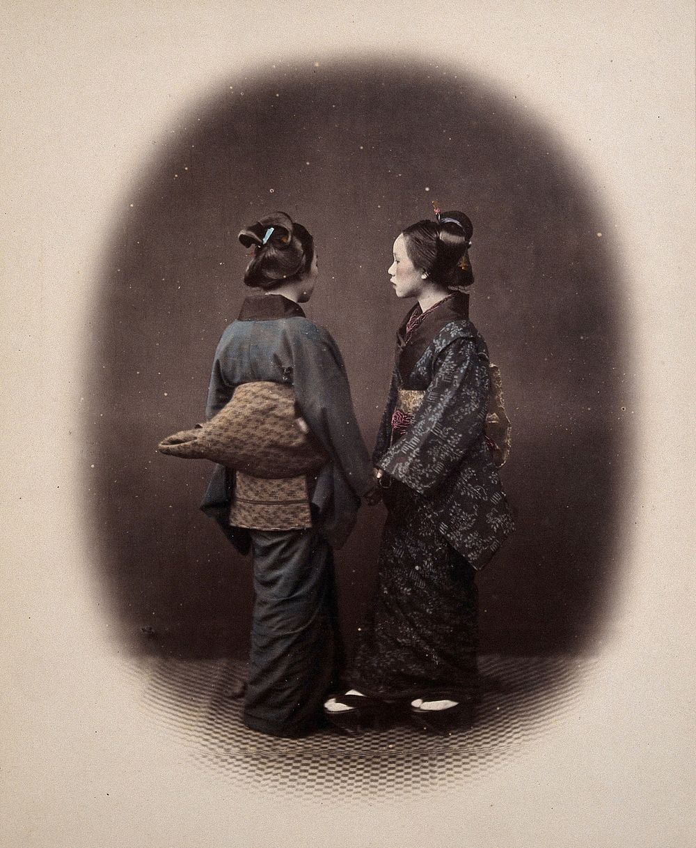 Two Japanese young women wearing traditional dress. Coloured photograph by Felice Beato, ca. 1870.