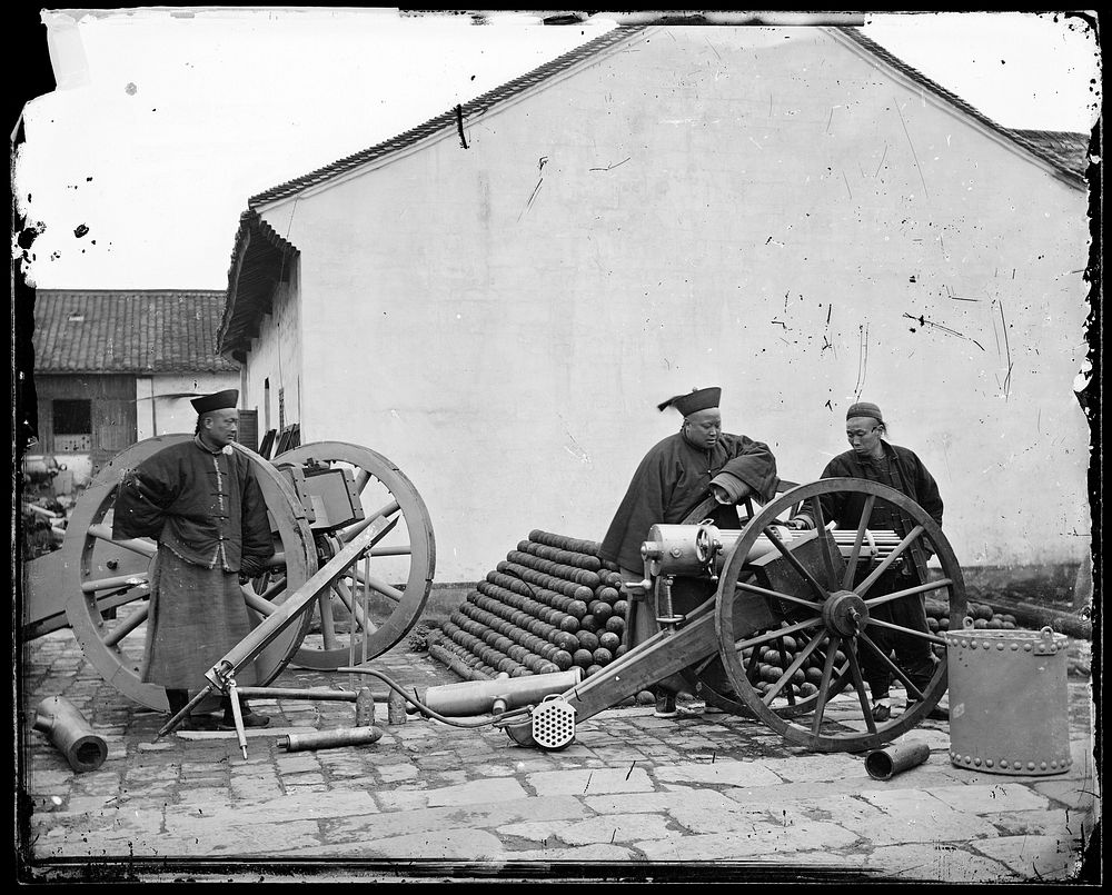 Nanking, Kiangsu province, China: three men examining a gun at the arsenal. Photograph by John Thomson, 1871.