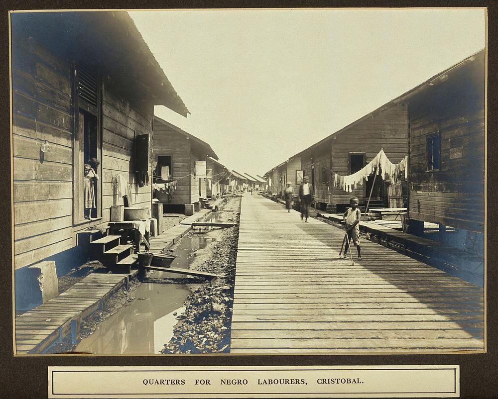 Panama Canal workers' (West Indian and Panaman) quarters: exterior view of wooden huts with resident children in foreground.…