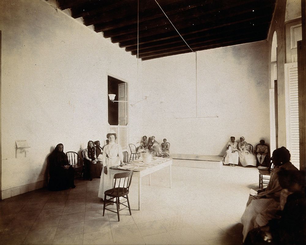 Waiting room in a dispensary for the treatment of tuberculosis, Cuba: a nurse stands beside the reception table, surrounded…