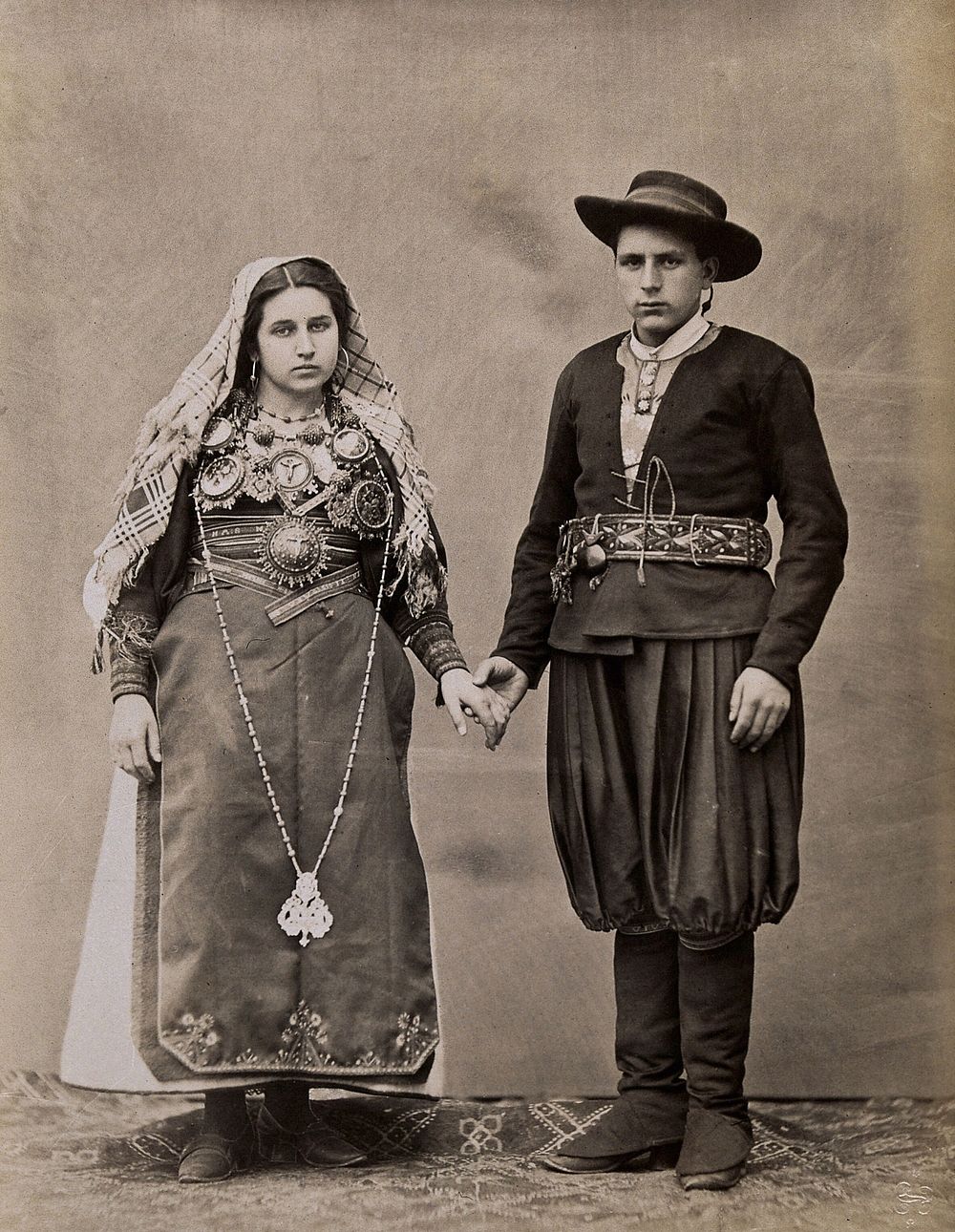 People of Leon, a man and woman holding hands, wearing traditional dress.