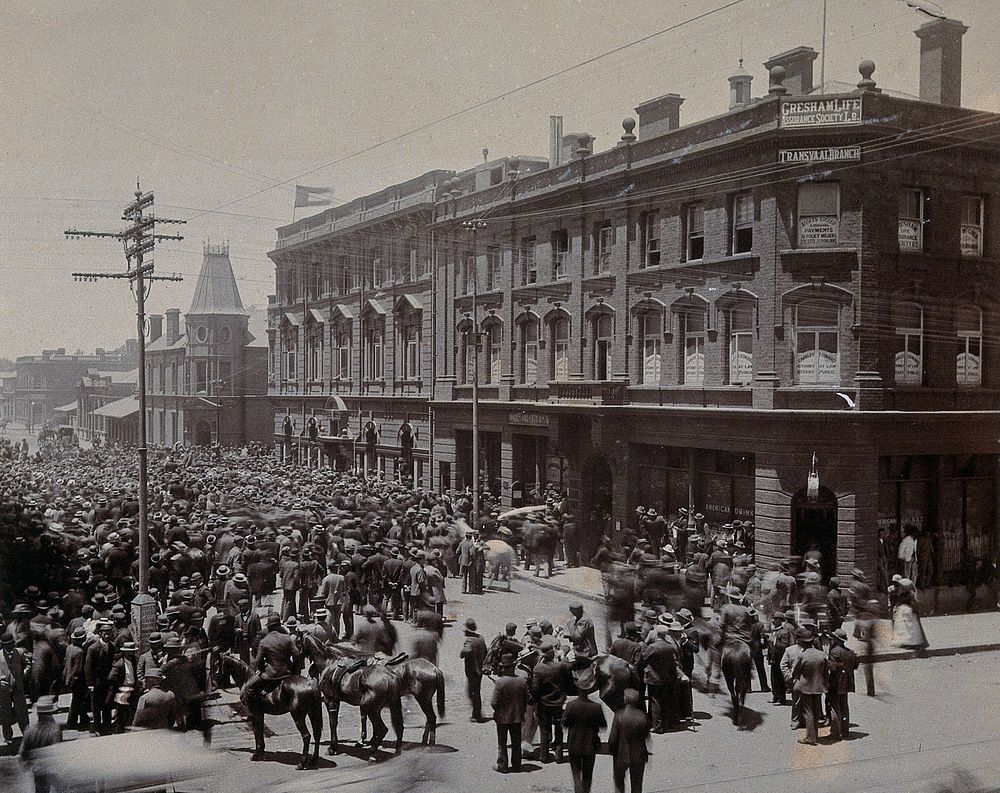 South Africa: a crowd of people gathered outside The Goldfields offices in Johannesburg. 1896.