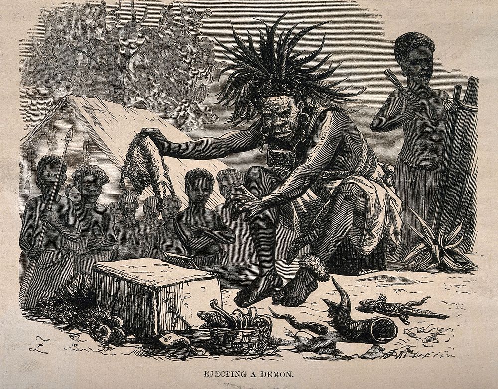 An African medicine man or shaman using symbols and small animals to eject a demon (disease). Wood engraving by Dalziel…