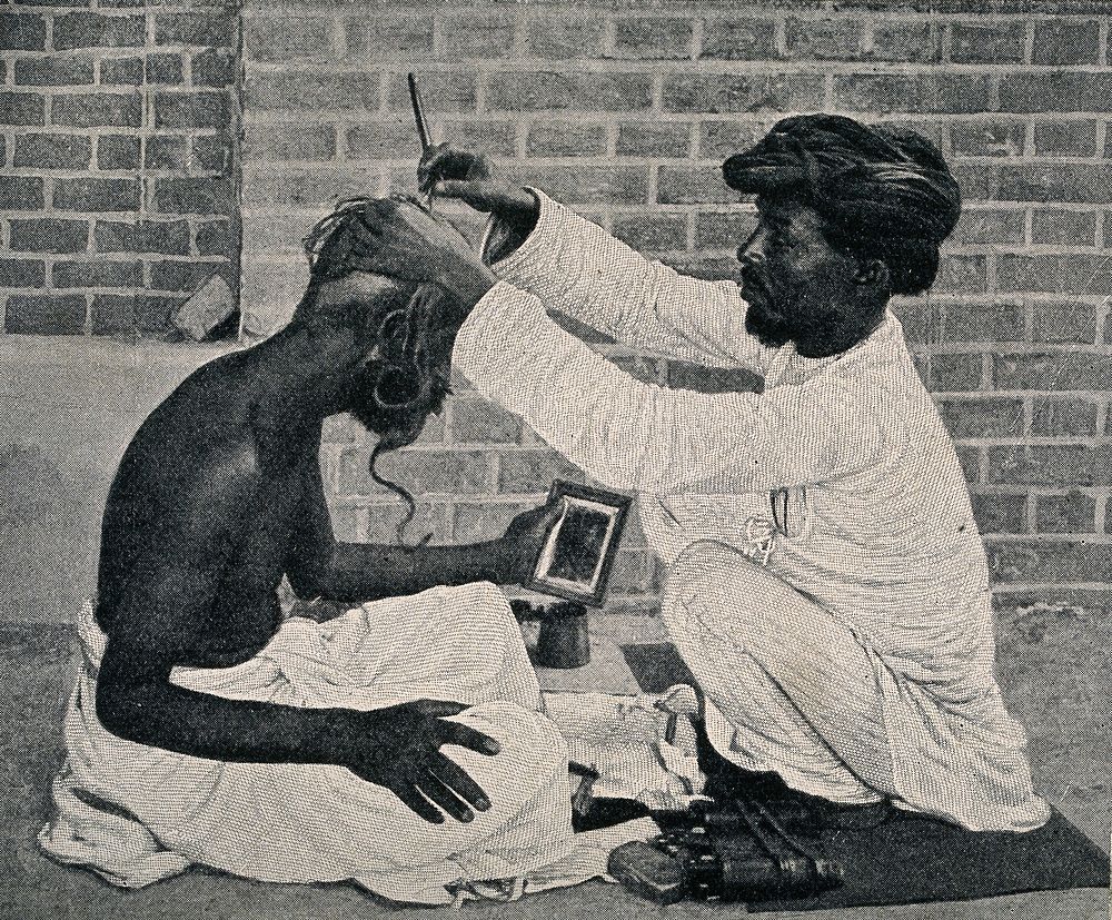An amateur barber dressing a man's hair in a street. Process print.