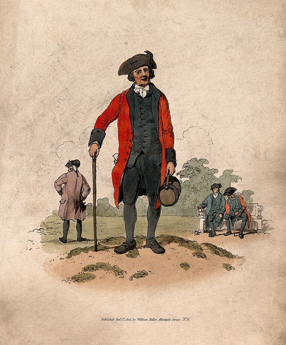 A Chelsea Pensioner, standing, wearing scarlet coat, and tricorn hat with a sprig of oak on it, leaning on a stick and…