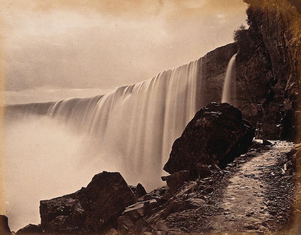 Niagara Falls: the Canadian Falls; a walkway next to the falls showing graffiti carved into a rock. Photograph, ca. 1880.