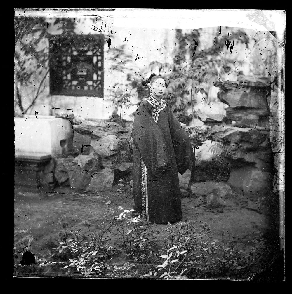 China: a young woman standing in a rock garden, Beijing. Photograph by John Thomson, 1869.