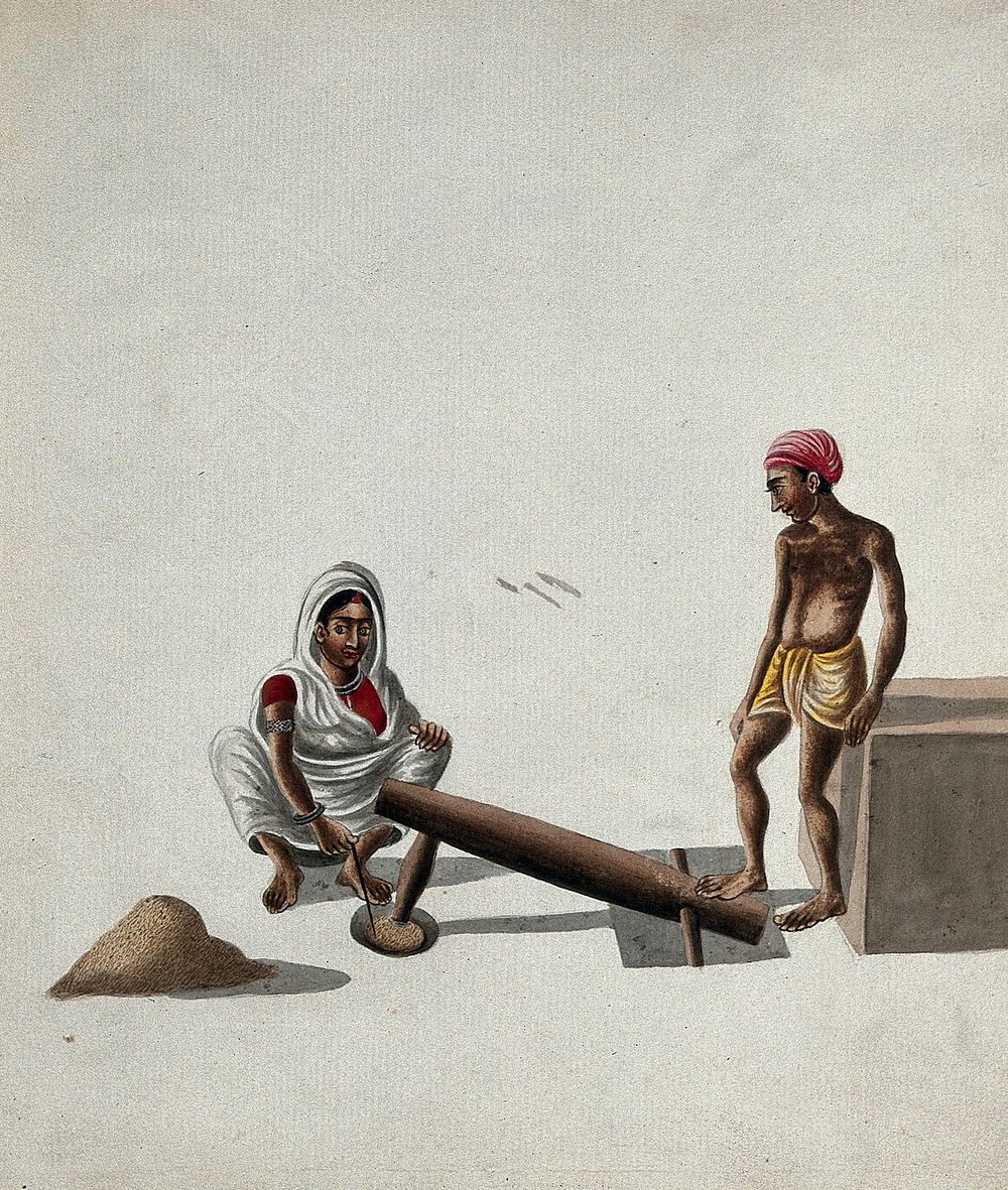 A man and a woman pounding and mixing grains or spices with a foot-operated mortar and pestle. Gouache painting by an Indian…